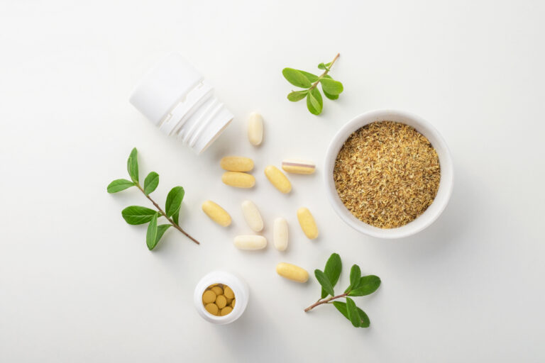 Vitamins and herbal supplements in jars with a green plant on a white background. Biologically active additives